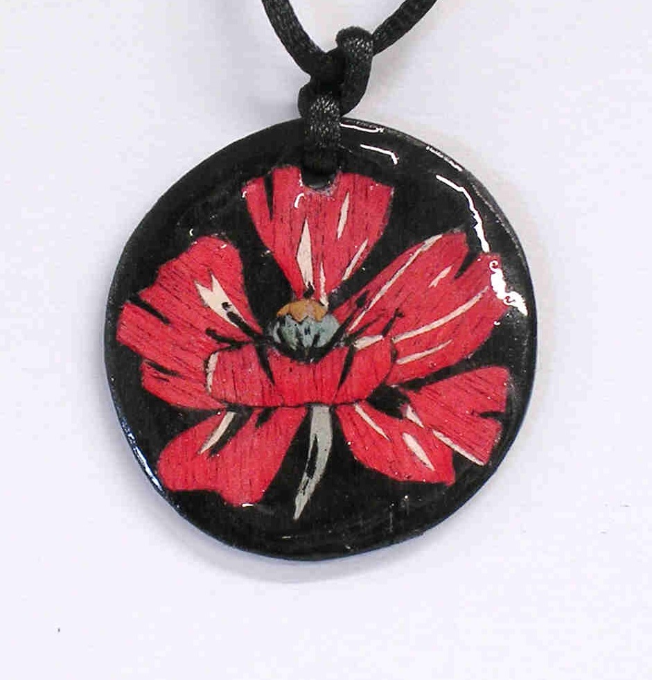 marquetry pendant with a black background and red poppy design
